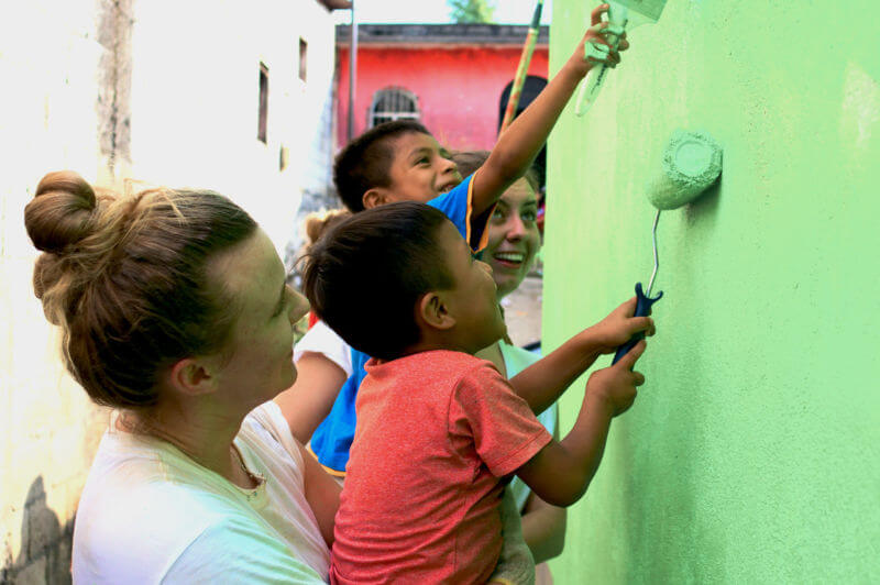 Theology Programs 8 SJC student paints a wall in a Guatemalan home