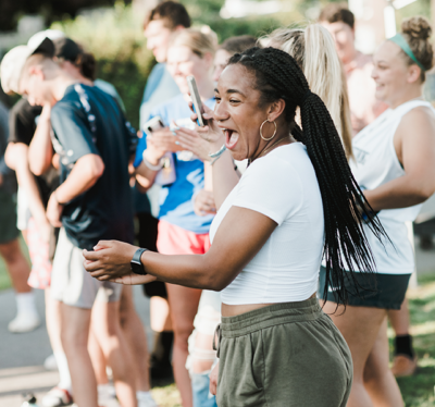 Student cheering her classmates on during a game at Welcome Weekend.