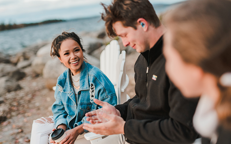 3 students chat down at the lake