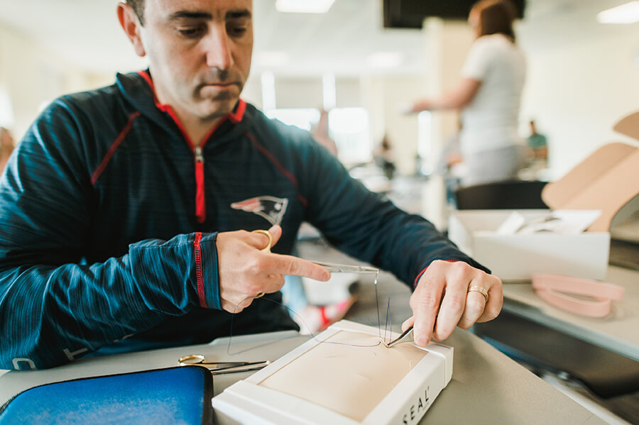 healthcare student works on suturing skills