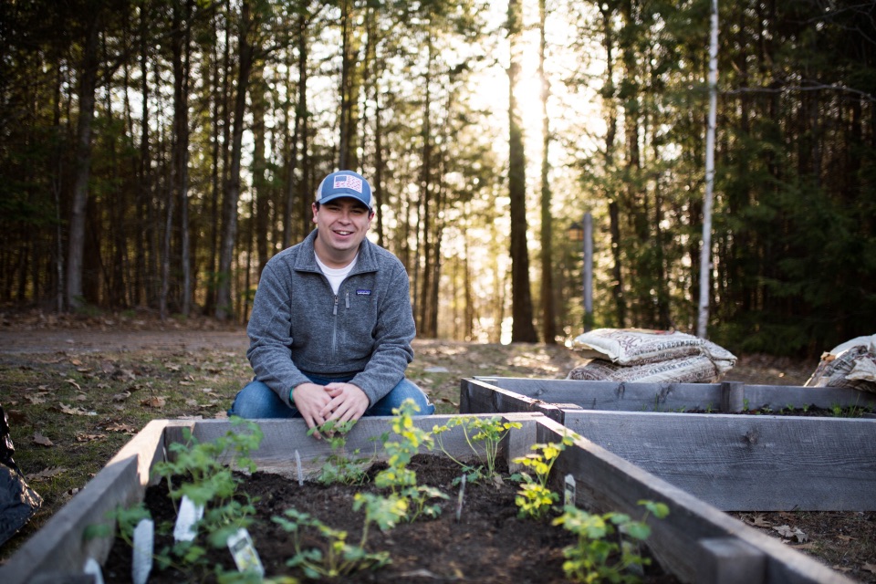 Caleb Gravel at the bee pollinator garden at Saint Joseph's College of Maine
