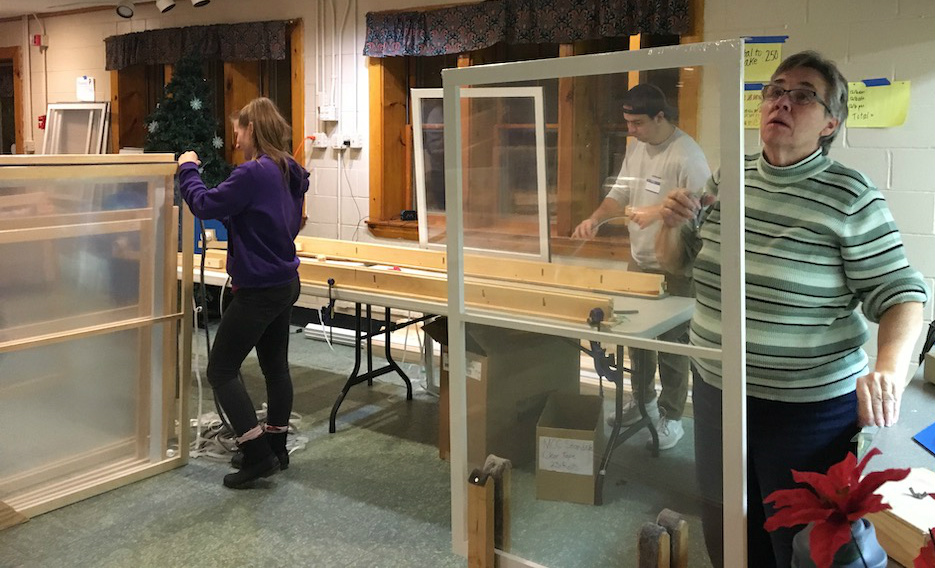students work on window weatherization project