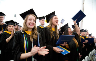 Saint Joseph’s College Confers 581 Degrees To The Class Of 2018 2 A group of graduates in caps and gowns from Saint Joseph’s College celebrate during the Class of 2018 graduation ceremony; some are clapping and holding their degrees. Saint Joseph's College of Maine