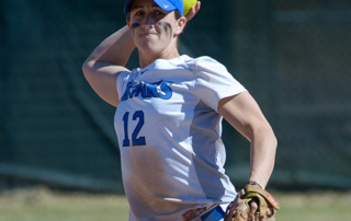 3 Questions For…Theresa Hendrix ‘15 • Sjc’s Superwoman 7 A softball player wearing a blue cap and white jersey with the number 12, reminiscent of Theresa Hendrix, prepares to throw the ball while holding a glove in the other hand. Saint Joseph's College of Maine