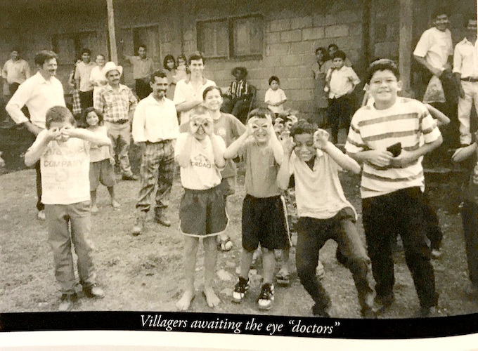 Children in Honduras playfully mimic eyeglasses with their hands.