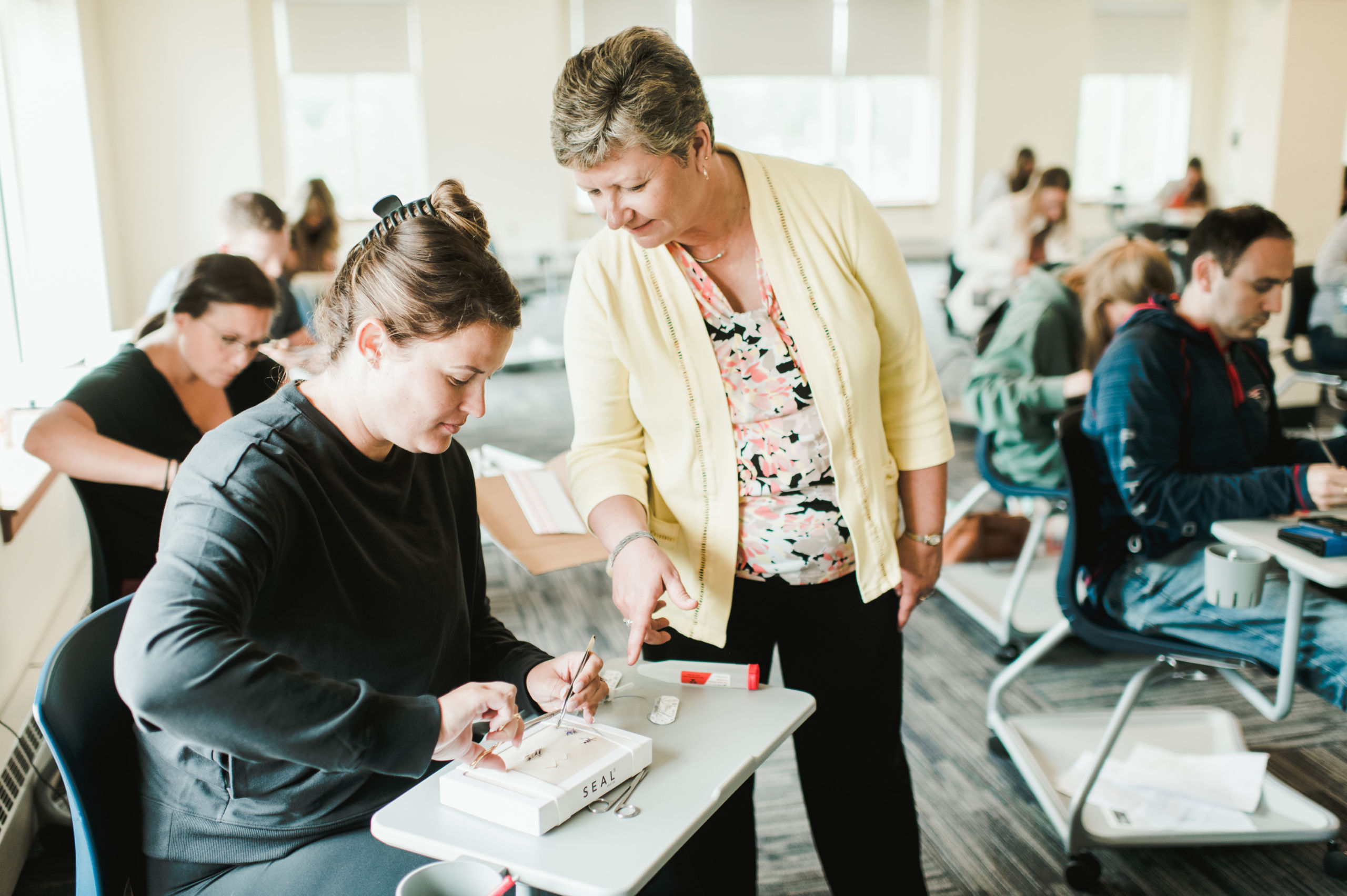 Nursing professor helps online nursing student with suturing
