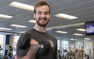 Return On Investment 1 Tommy Dahlborg '18 lifts a weight in the fitness center.