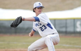 Softball And Baseball Teams Earn Conference Championships 4 A baseball player wearing a white and blue uniform with the number 23 is in the process of throwing a pitch, perhaps during one of the conference championships. Saint Joseph's College of Maine