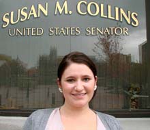 Beyond Red States And Blue States 2 A woman stands in front of a window with the text "Susan M. Collins, United States Senator" written on it, representing a figure respected across both red states and blue states. Saint Joseph's College of Maine