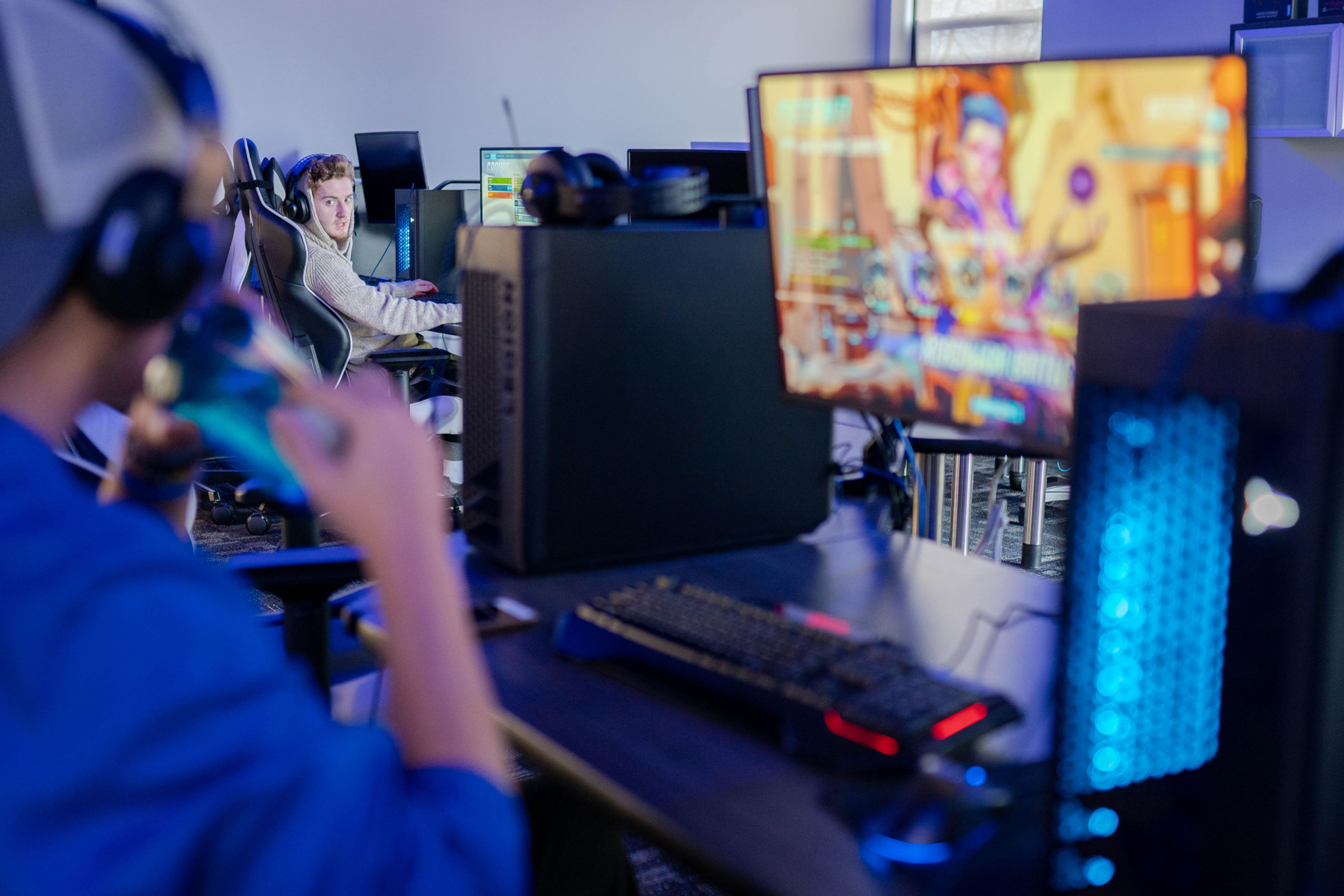 clubs-and-orgs-scaled People are playing video games on desktop computers in a gaming setup, with one person in focus and another blurred in the foreground. The screen displays a colorful game, creating an immersive experience reminiscent of campus life and admissions events. Saint Joseph's College of Maine
