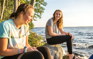 Admissions Office To Host Fall Events 2 Saint Joseph's College of Maine students sitting at the lakefront