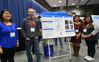 Team Of Saint Joseph’s College Students Win Award At Maine Sustainability And Water Conference 1 Four people stand by a research poster at a conference with posters in the background. The poster, titled "Local and Sustainable: Promoting the Campus Store," highlights initiatives at Saint Joseph’s College. Saint Joseph's College of Maine
